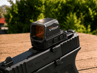 VPDOT solar red dot sight mounted on a black pistol, red dot visible in lens, outdoor background.